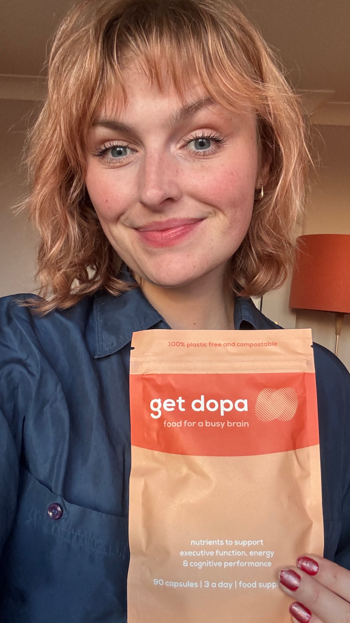 Woman holding 'get dopa' with a neutral background