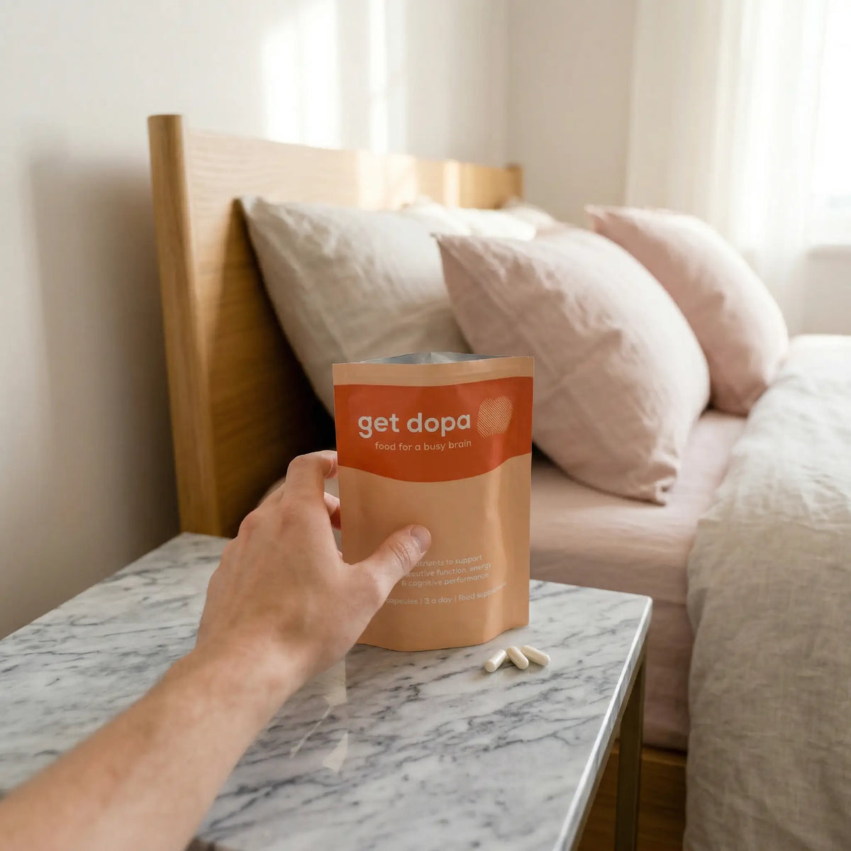 male arm reaching for get dopa pouch with three capsules on the side. 